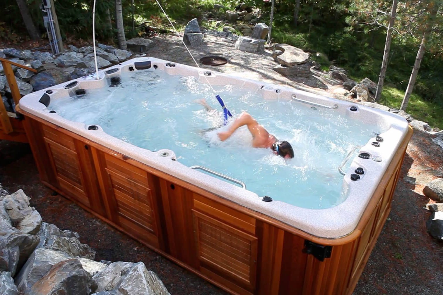 Un nageur à contre-courant dans un spa de nage à cabinet de cèdre, en forêt